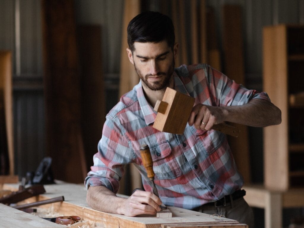 Furniture Maker Using A Chisel
